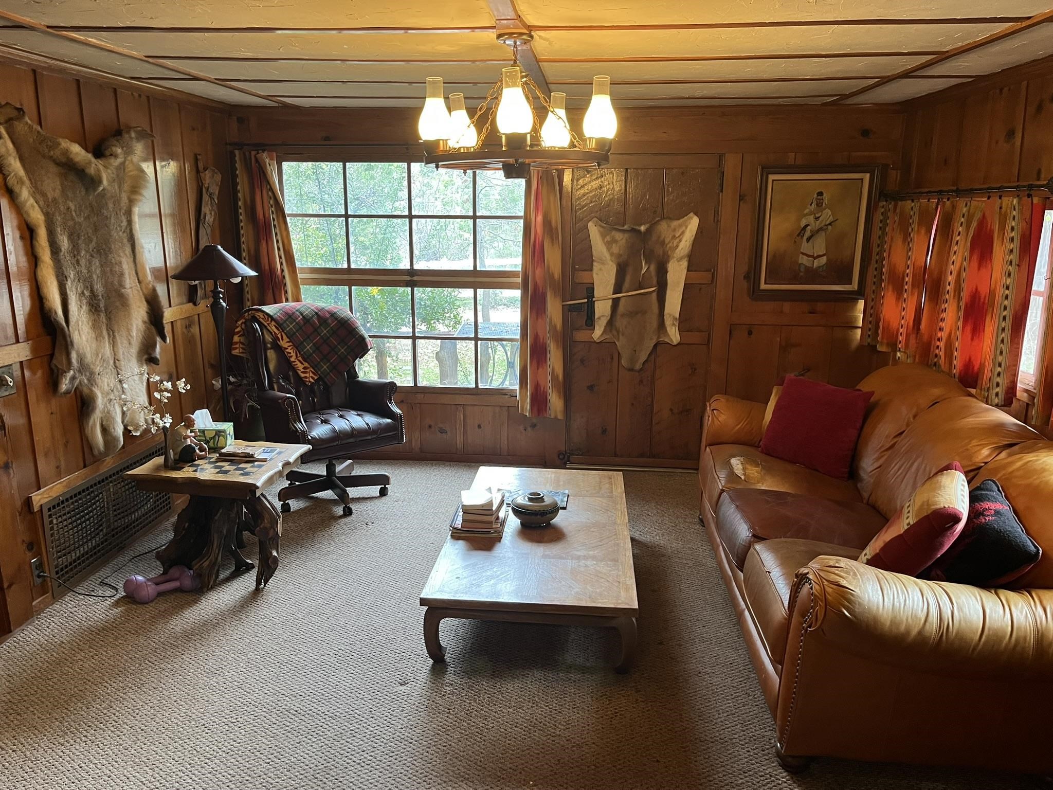 23090 North Bald Mountain Road Sonora, CA 95370 - Photo 7 of 59 Carpeted living room featuring hanging lights, wood walls, and heating unit