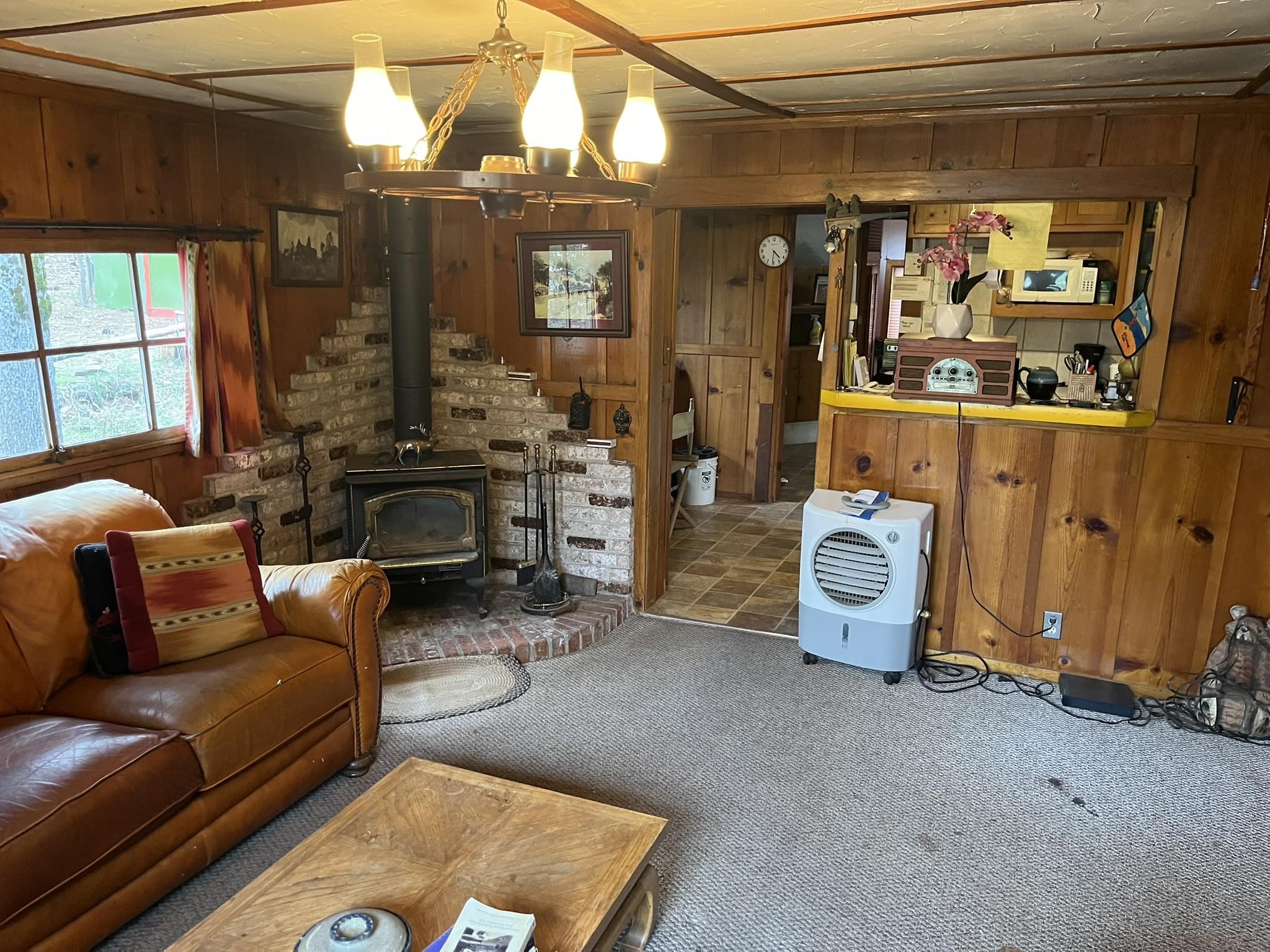 23090 North Bald Mountain Road Sonora, CA 95370 - Photo 8 of 59 Carpeted living area with wooden walls and a wood stove