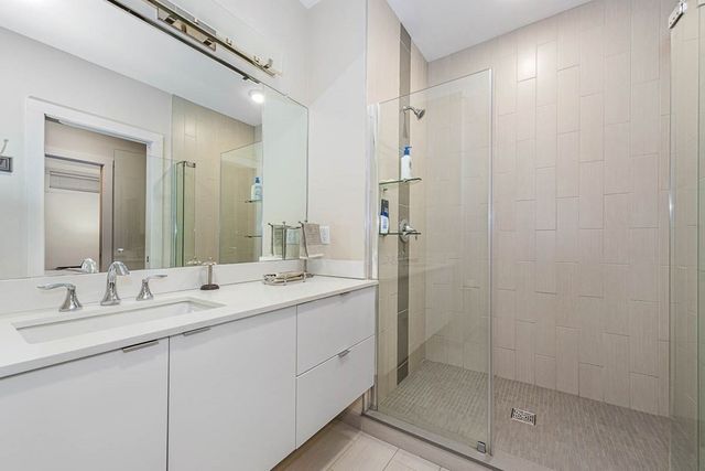 a bathroom with a double vanity sink mirror and shower