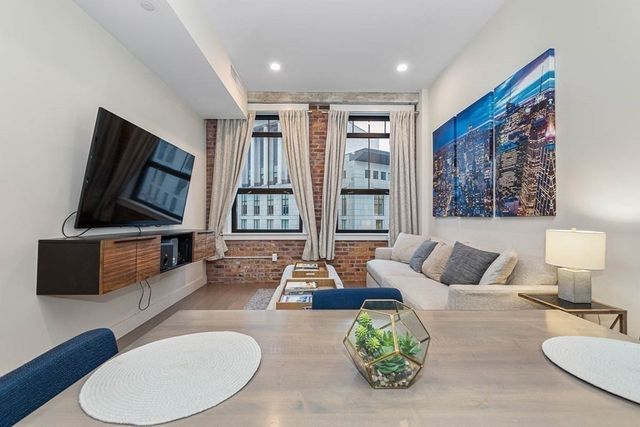 a living room with furniture a flat screen tv and a large window
