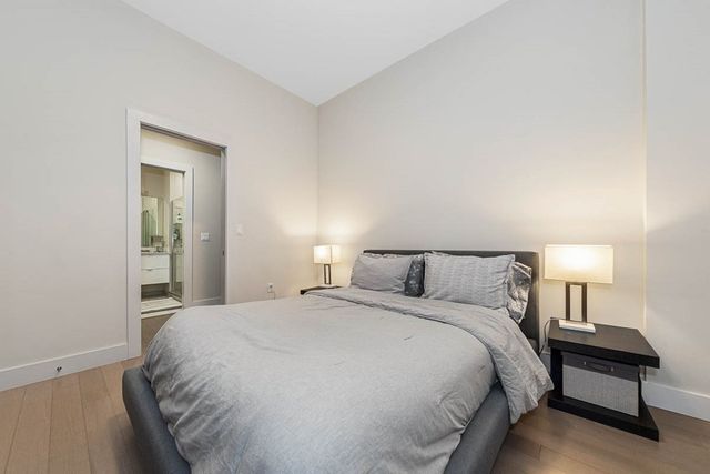 a large bed sitting in a bedroom next to a lamp and a lamp