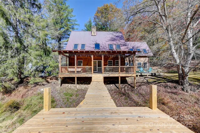 a view of house with large trees and outdoor seating