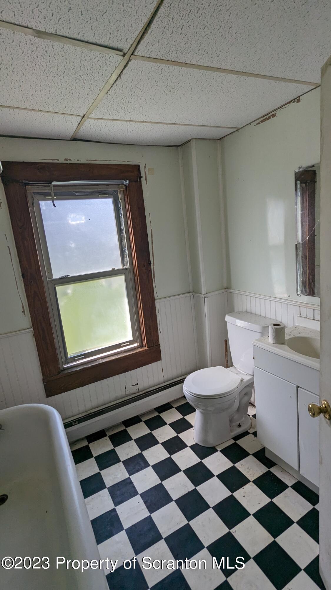 357 Hughes Court Scranton, PA 18504 - Photo 4 of 16 a bathroom with a black white checkered floor and a toilet