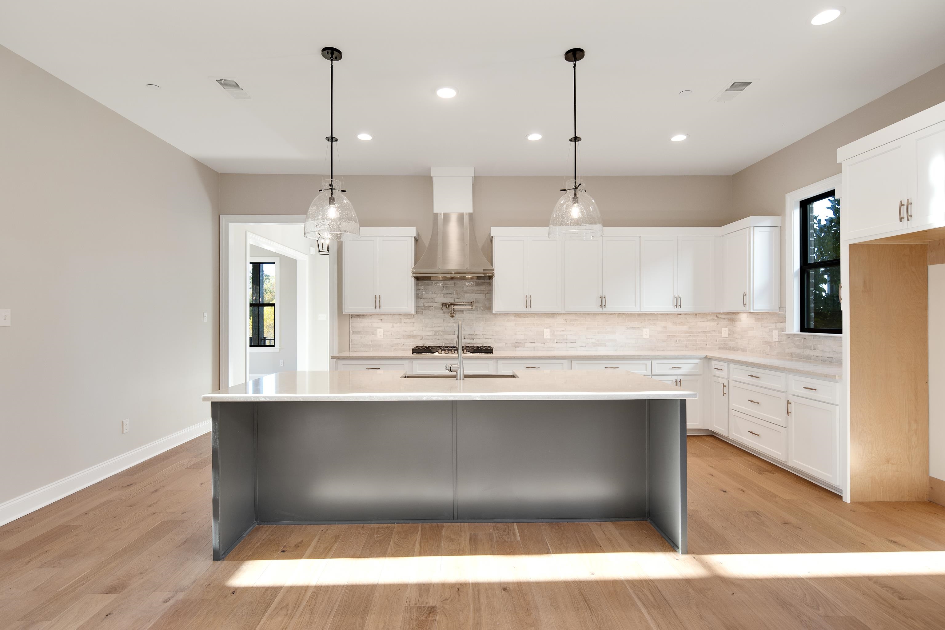 300 Mary Taylor Way Piperton, TN 38017 - Photo 13 of 36 Kitchen featuring white cabinets, light hardwood / wood-style floors, and a healthy amount of sunlight