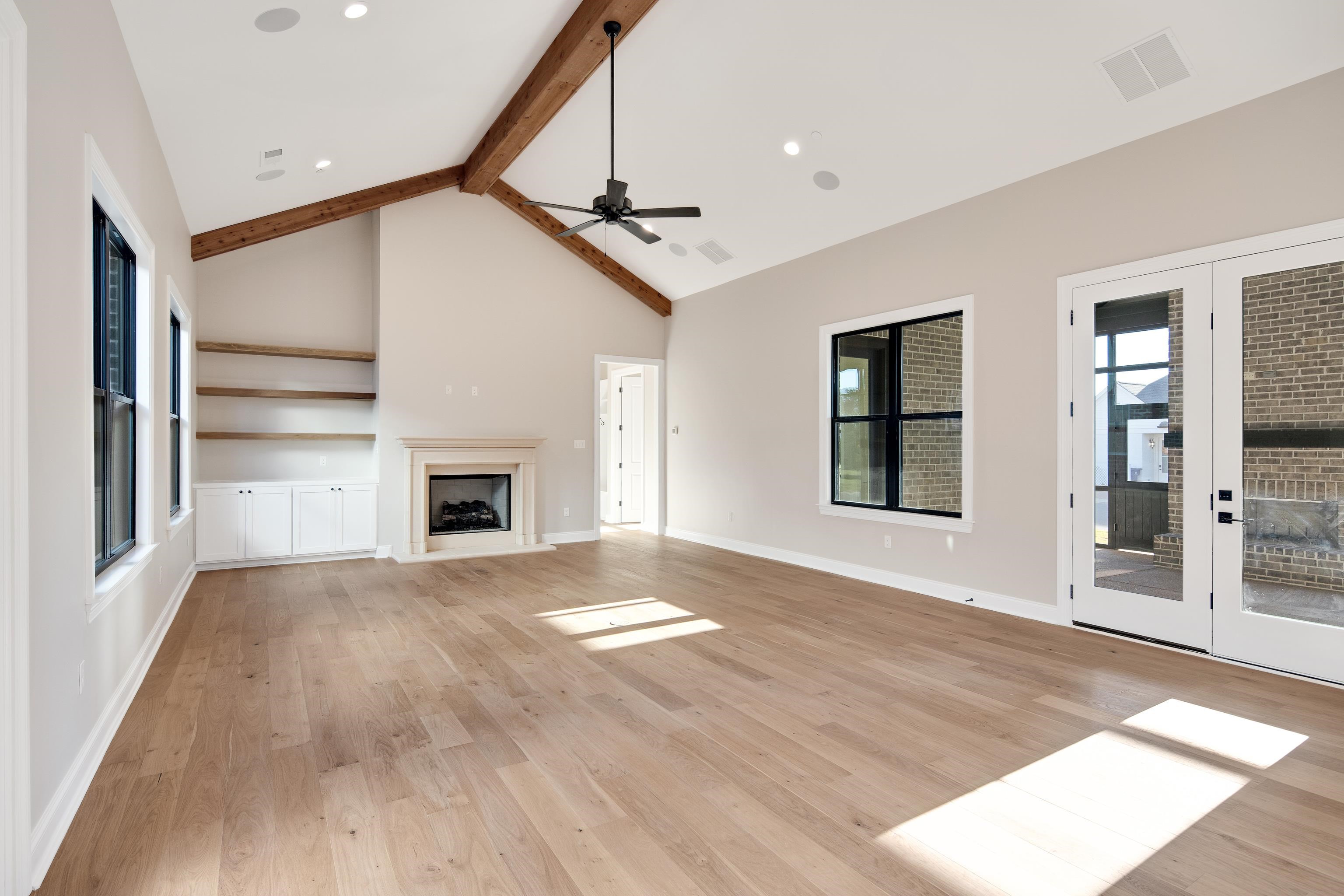 300 Mary Taylor Way Piperton, TN 38017 - Photo 14 of 36 Unfurnished living room featuring french doors, ceiling fan, high vaulted ceiling, beamed ceiling, and light hardwood / wood-style floors