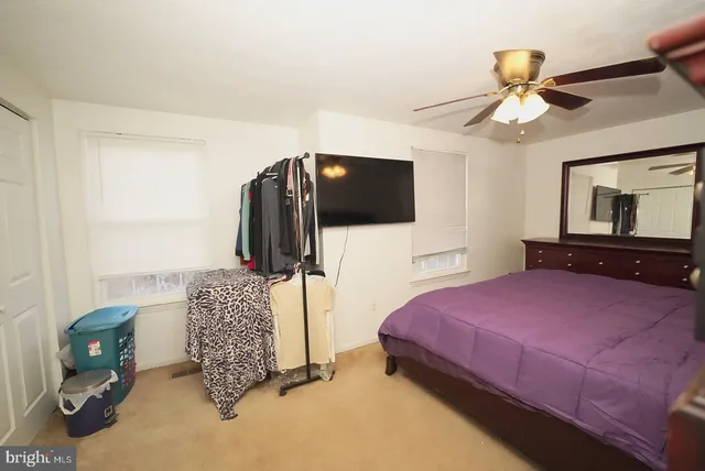 a bedroom with a bed and a flat tv screen on dresser