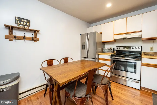 a kitchen with a table chairs refrigerator and microwave