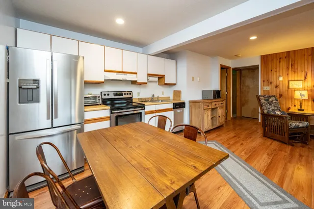 a kitchen with stainless steel appliances wooden floor and refrigerator