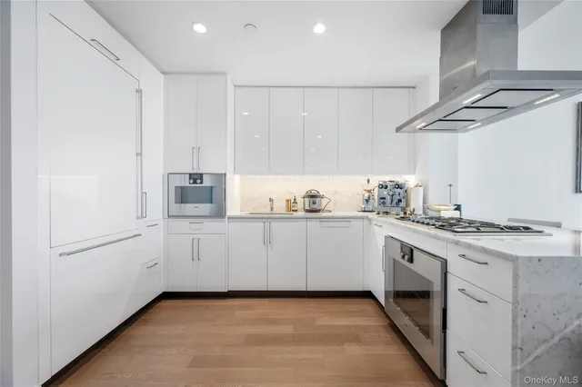 a kitchen with granite countertop white cabinets and white appliances