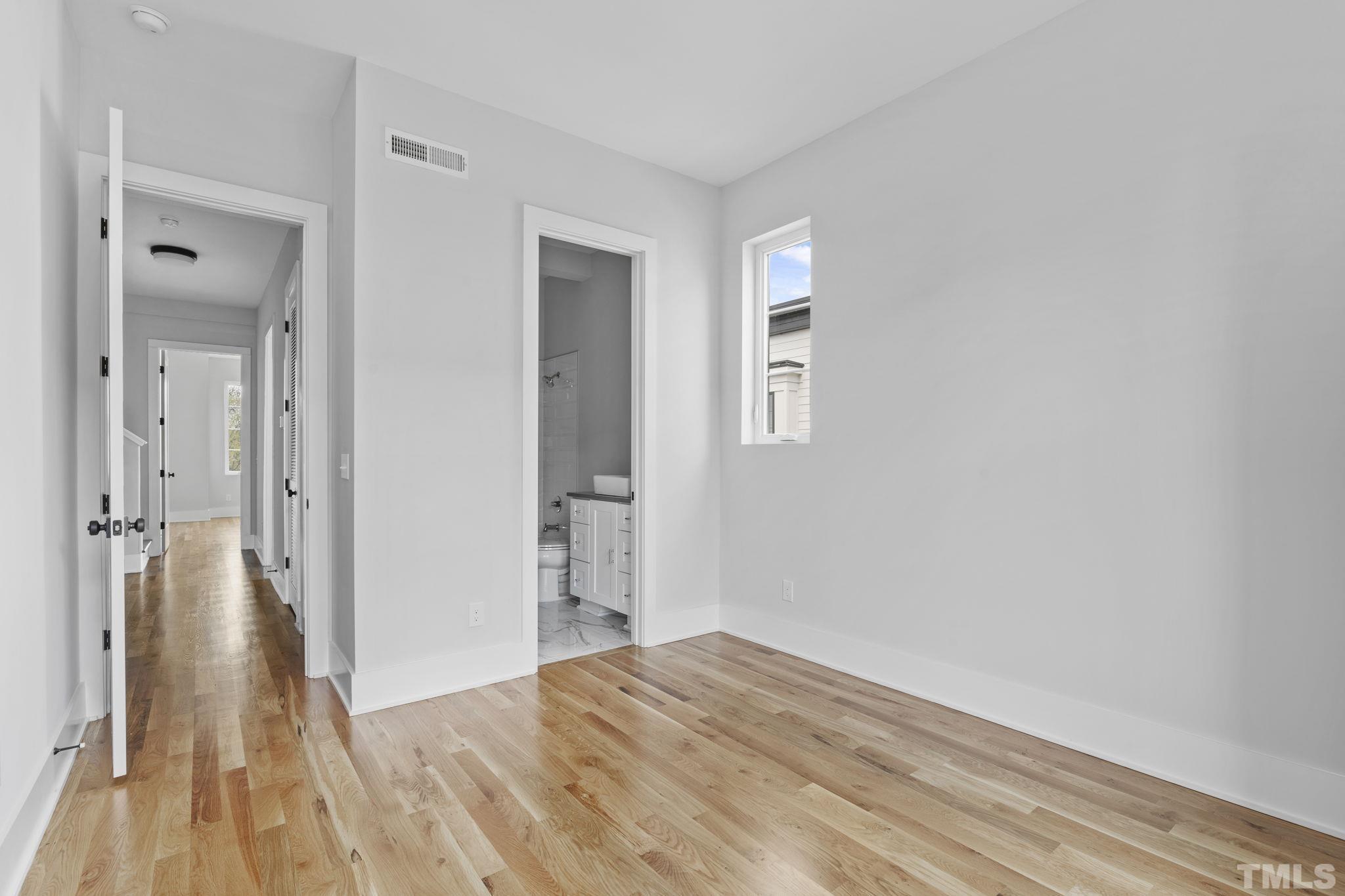 407 West Lenoir Street Raleigh, NC 27601 - Photo 19 of 42 a view of a bedroom with wooden floor and a bathroom