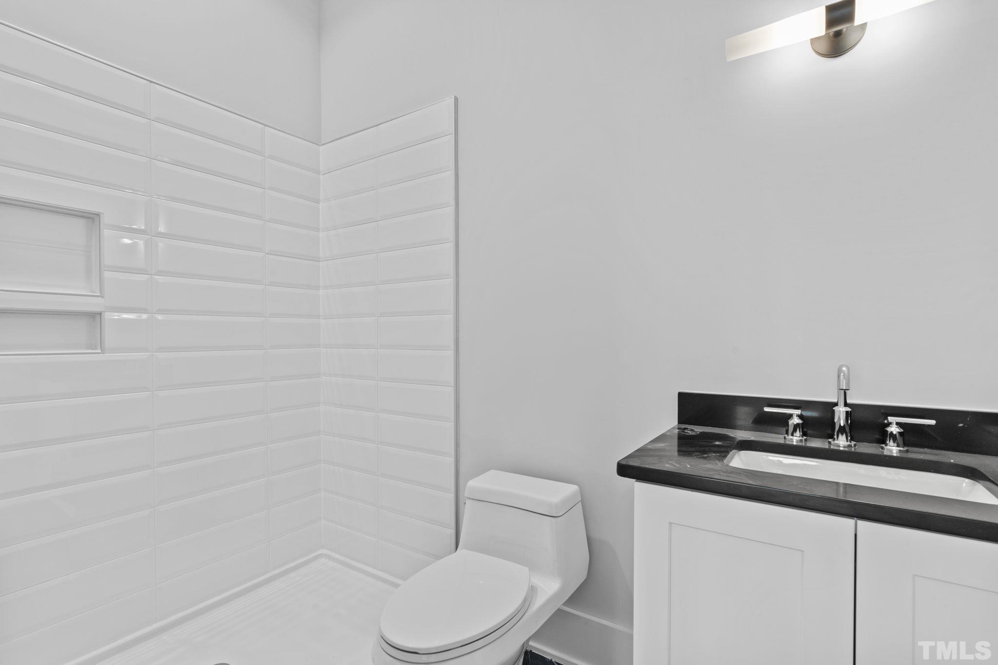 407 West Lenoir Street Raleigh, NC 27601 - Photo 31 of 42 a bathroom with a granite countertop toilet sink and mirror