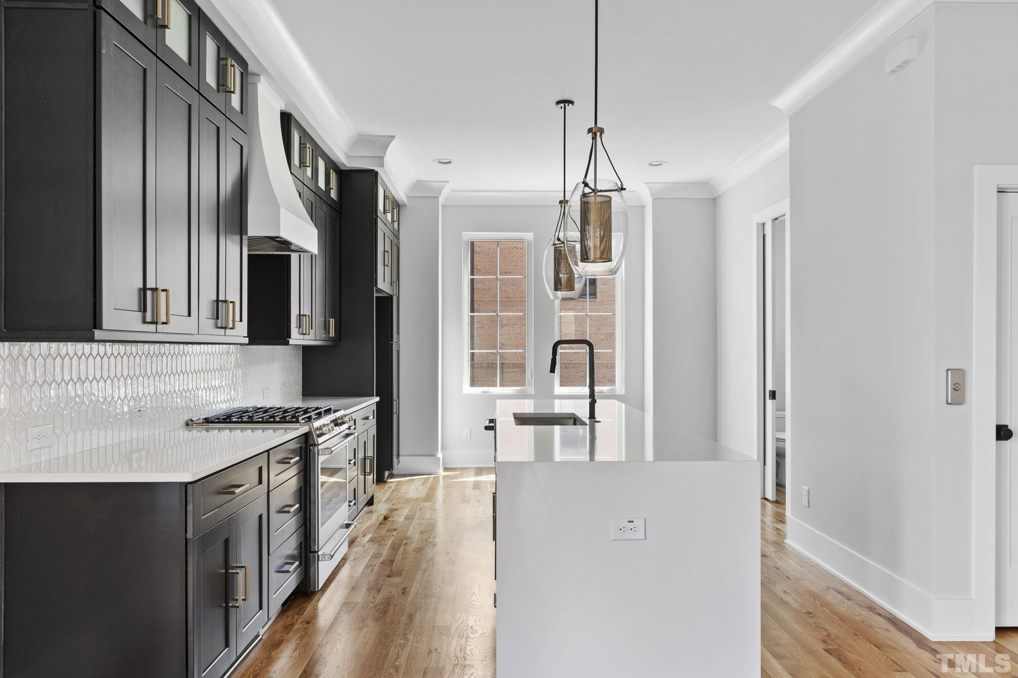 407 West Lenoir Street Raleigh, NC 27601 - Photo 4 of 42 a kitchen with stainless steel appliances granite countertop a refrigerator a stove and a sink with wooden floor