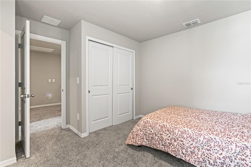 32502 Limitless Place Wesley Chapel, FL 33545 - Photo 32 of 67 a bedroom with a bed and a cabinets