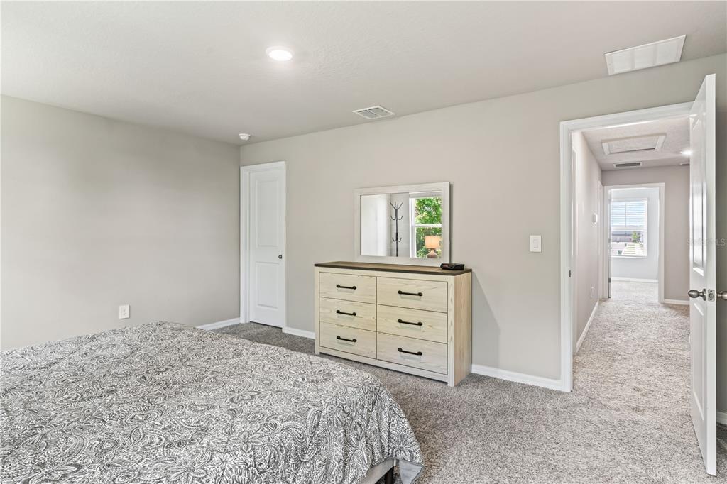 32502 Limitless Place Wesley Chapel, FL 33545 - Photo 41 of 67 a bedroom with a bed and a dresser