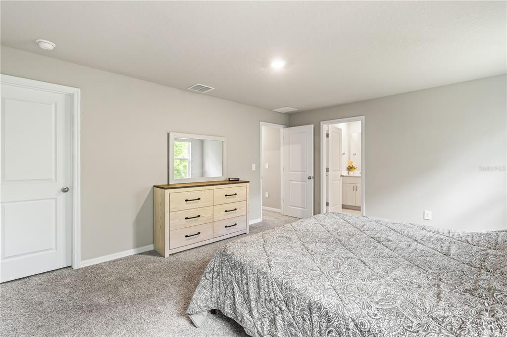 32502 Limitless Place Wesley Chapel, FL 33545 - Photo 42 of 67 a bedroom with a bed and a dresser