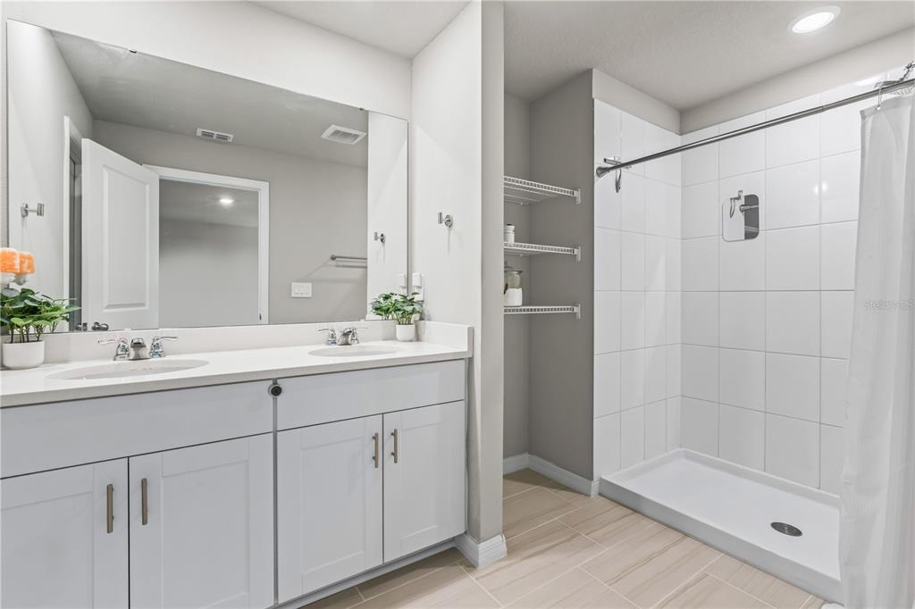 32502 Limitless Place Wesley Chapel, FL 33545 - Photo 44 of 67 a bathroom with a shower sink and mirror