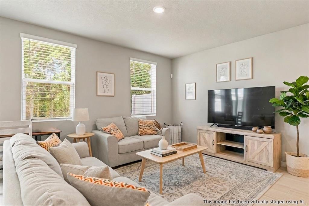 32502 Limitless Place Wesley Chapel, FL 33545 - Photo 6 of 67 a living room with furniture a flat screen tv and a window