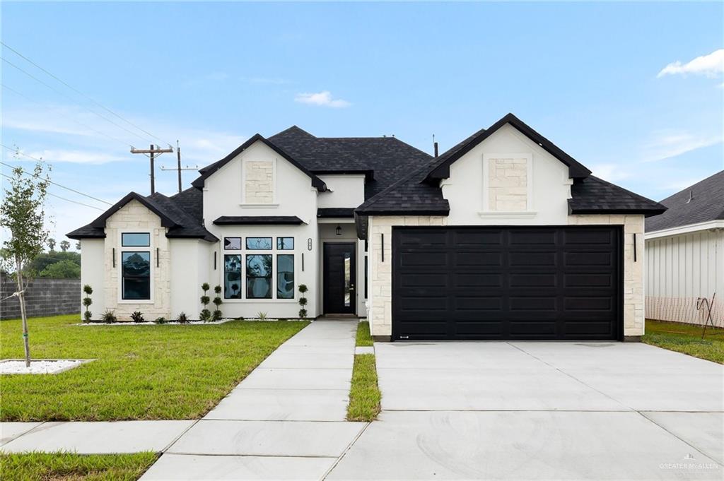 a front view of a house with a yard and garage