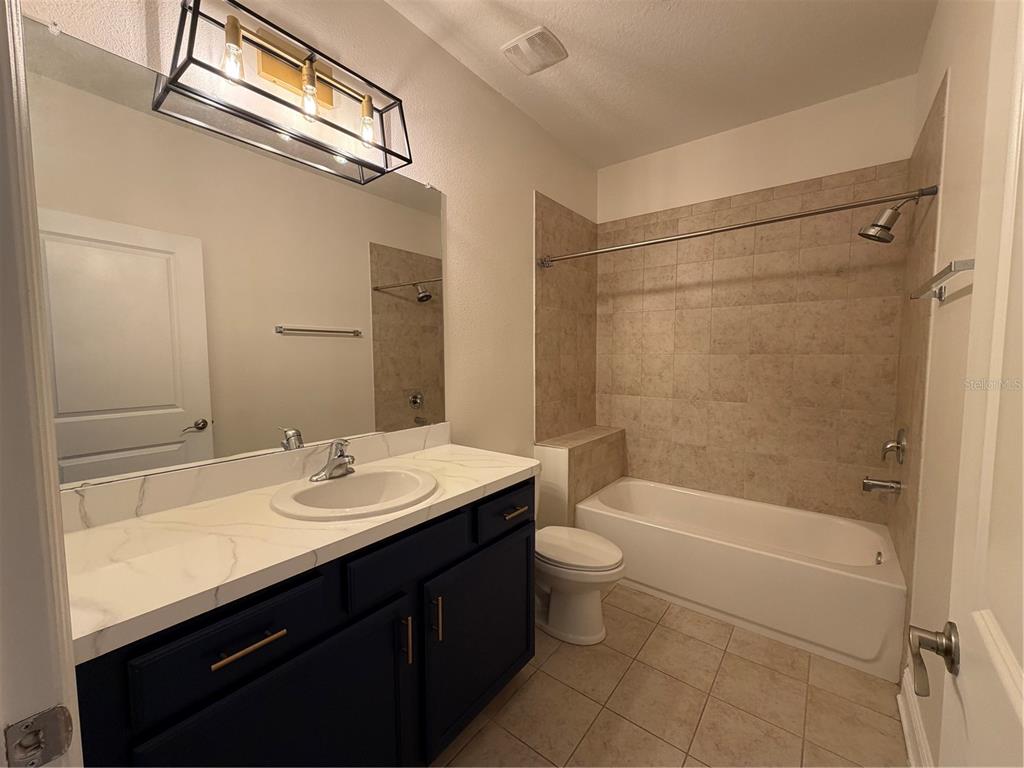 1736 West Walnut Street Tampa, FL 33607 - Photo 16 of 22 a bathroom with a sink a toilet a mirror and shower