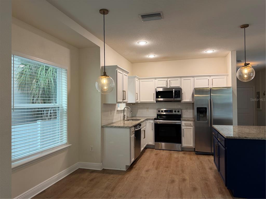 1736 West Walnut Street Tampa, FL 33607 - Photo 5 of 22 a kitchen with stainless steel appliances granite countertop a refrigerator a sink dishwasher a stove and a refrigerator