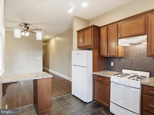 a view of a kitchen with sink and refrigerator