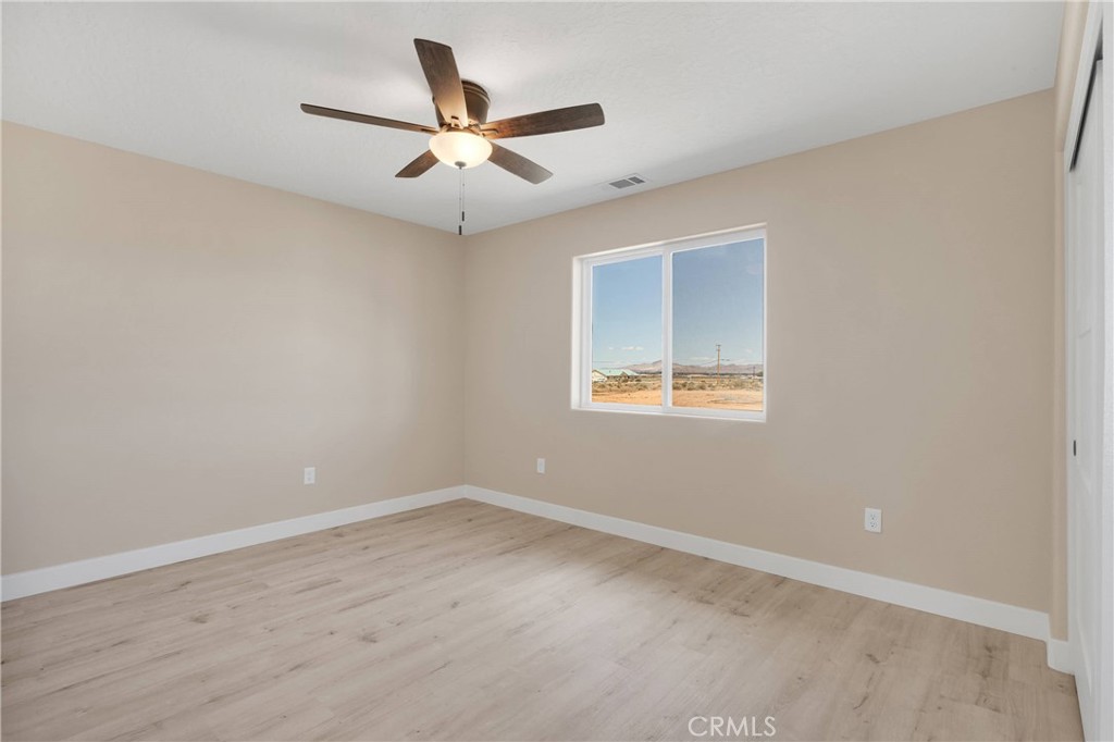 10647 Central Road Apple Valley, CA 92308 - Photo 23 of 27 an empty room with a window and a fan