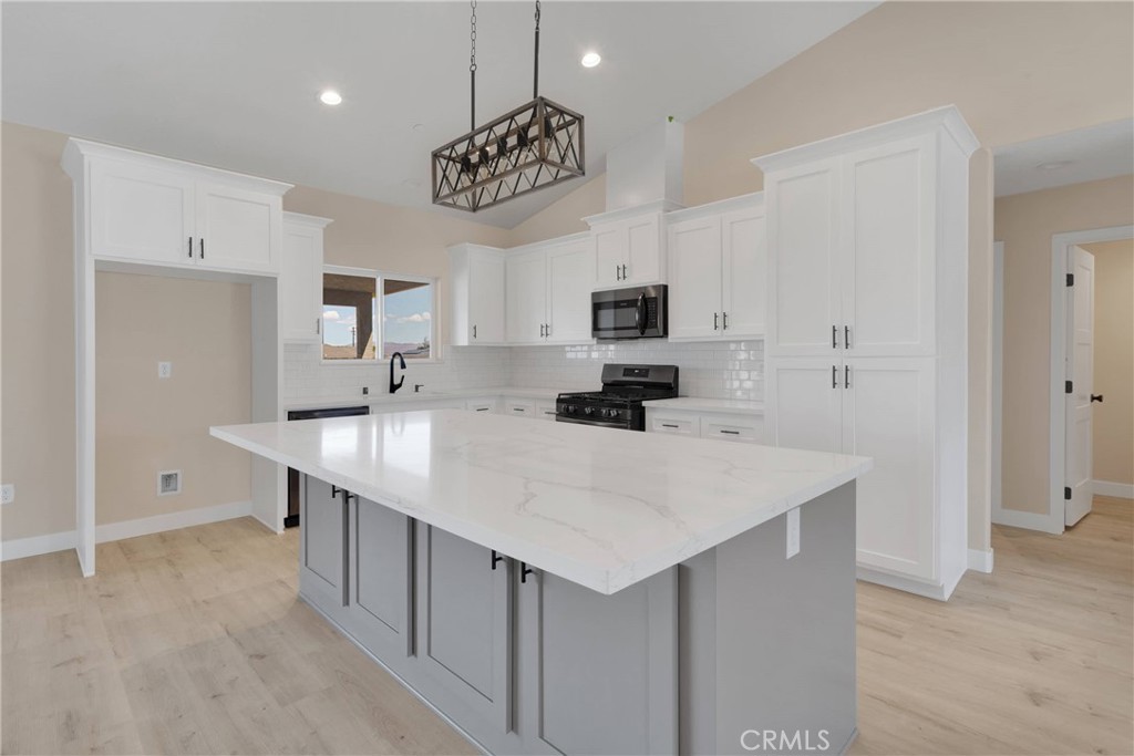 10647 Central Road Apple Valley, CA 92308 - Photo 7 of 27 a kitchen with kitchen island a sink counter space and appliances