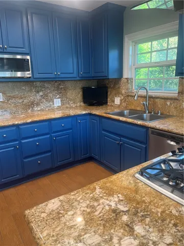 a kitchen with granite countertop wooden cabinets and stainless steel appliances