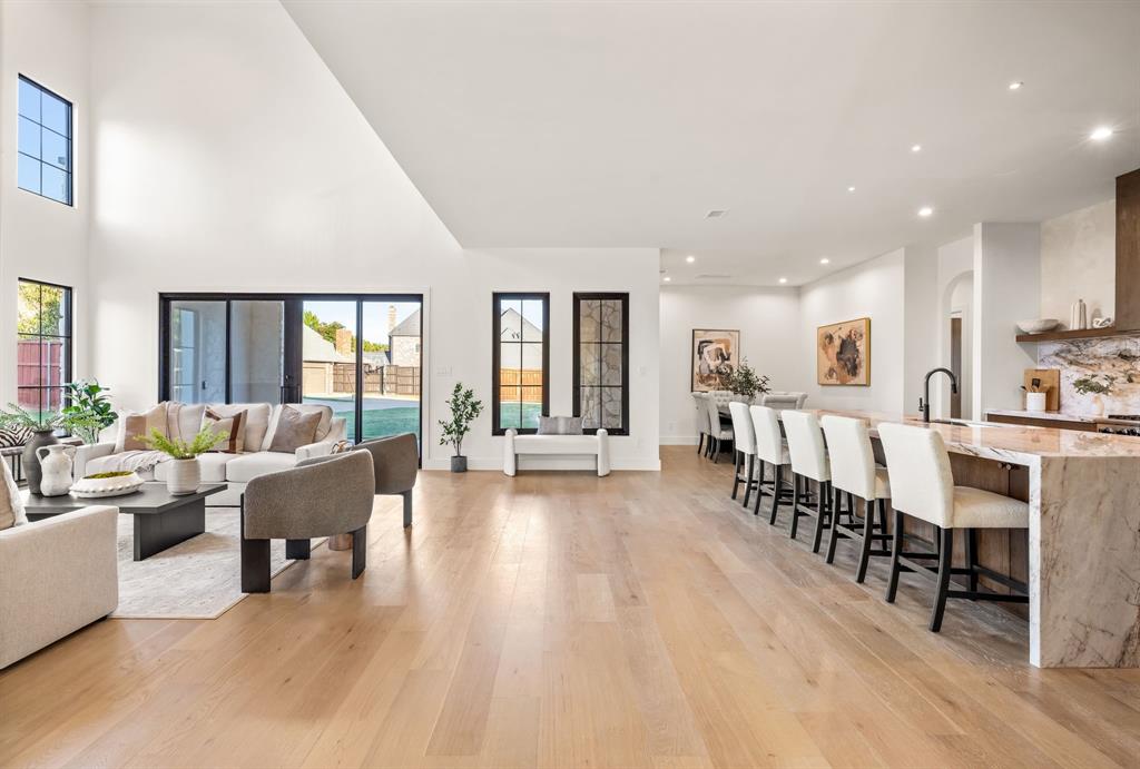 702 Mockingbird Lane Coppell, TX 75019 - Photo 11 of 32 Living area with light wood-type flooring, recessed lighting, arched walkways, and a high ceiling