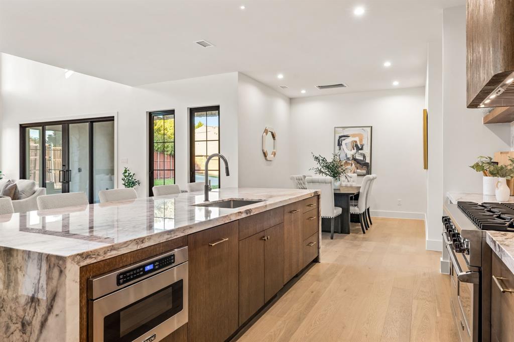 702 Mockingbird Lane Coppell, TX 75019 - Photo 14 of 32 Kitchen with light stone counters, appliances with stainless steel finishes, light wood-style floors, recessed lighting, and modern cabinets