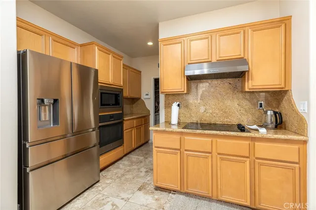 a kitchen with stainless steel appliances granite countertop a refrigerator sink and cabinets