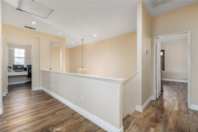 a view of a hallway with wooden floor and a living room