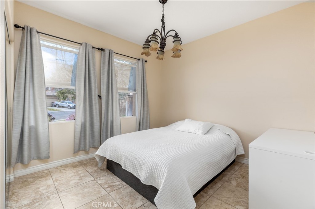 13490 Hawthorn Avenue Moreno Valley, CA 92553 - Photo 25 of 34 a bedroom with a bed and a chandelier