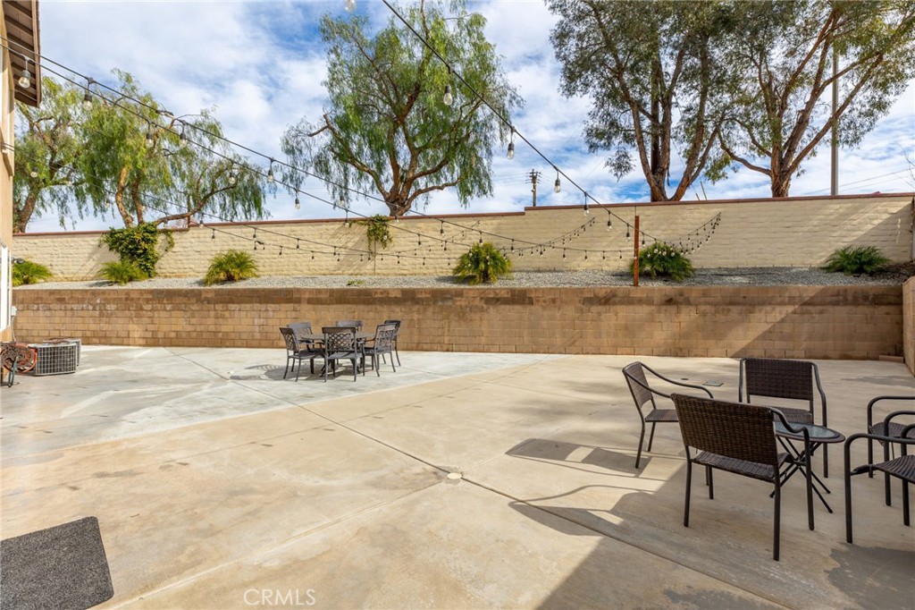 13490 Hawthorn Avenue Moreno Valley, CA 92553 - Photo 27 of 34 a view of a patio with table and chairs with wooden floor and fence