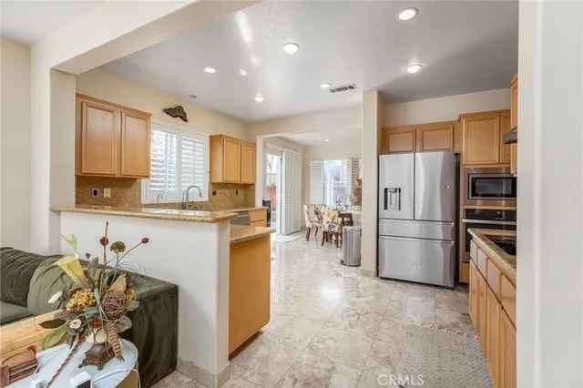 a kitchen with stainless steel appliances a refrigerator and a stove top oven