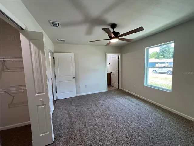 a view of an empty room and a ceiling fan