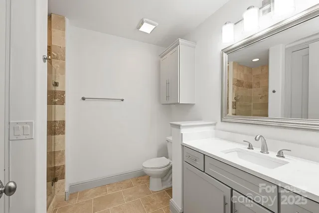 a bathroom with a granite countertop sink toilet and shower