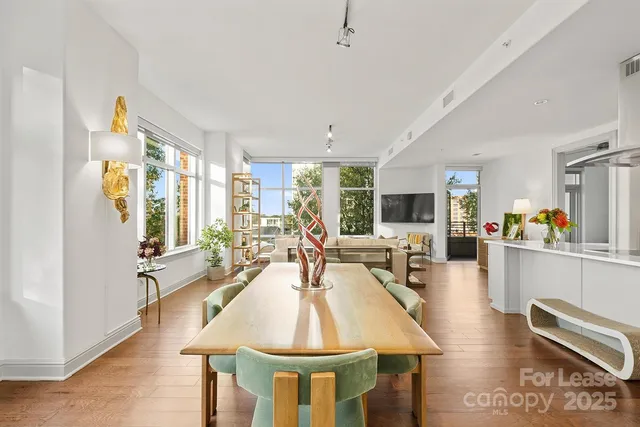a dining room with wooden floor and large window