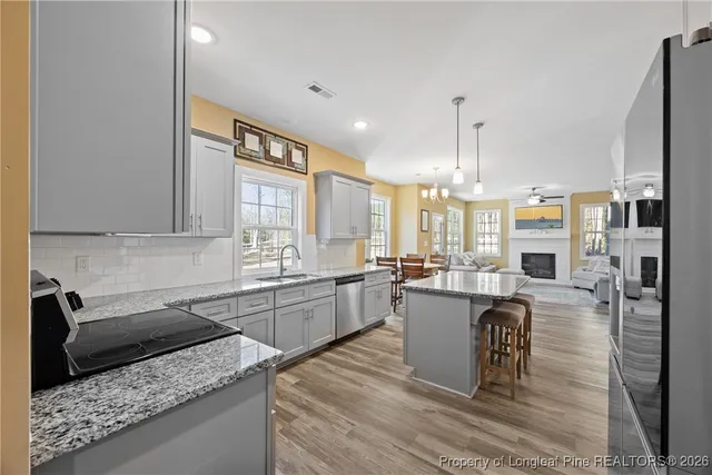 a kitchen with a sink a stove and chairs