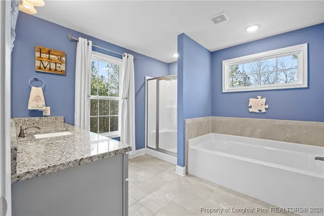 a bathroom with a granite countertop tub sink and mirror