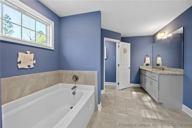 a bathroom with a tub sink and mirror