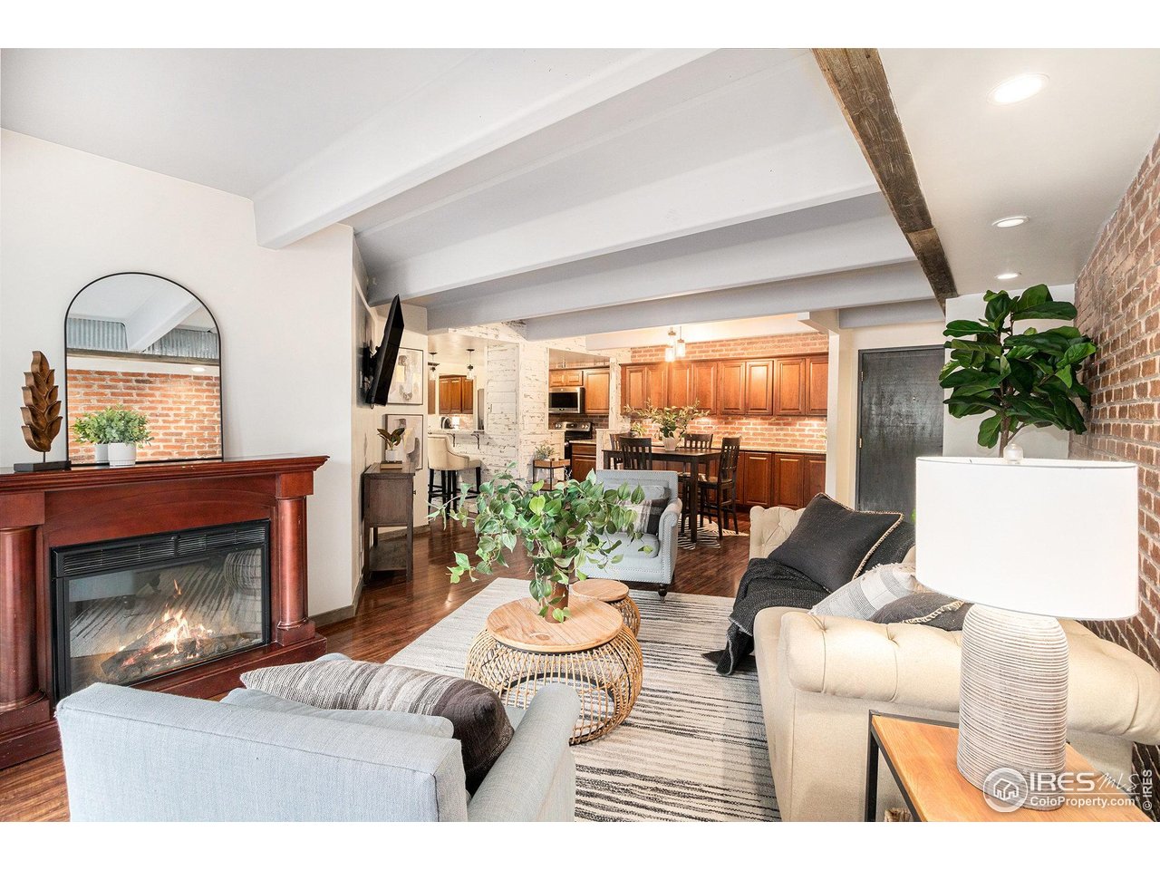 a living room with furniture a fireplace and a potted plant