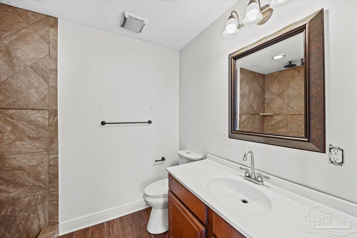 2521 Tomlinson Road Pensacola, FL 32526 - Photo 17 of 30 a bathroom with a sink mirror vanity and toilet