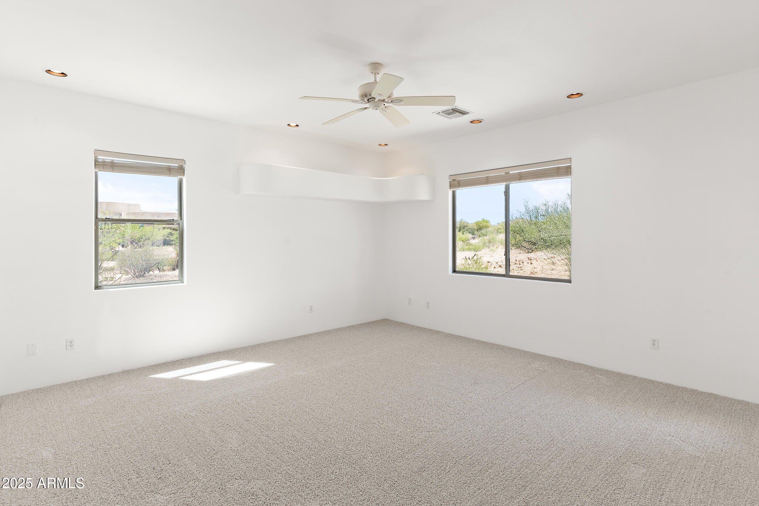 14036 East Ranch Road Scottsdale, AZ 85262 - Photo 14 of 32 an empty room with windows and ceiling fan