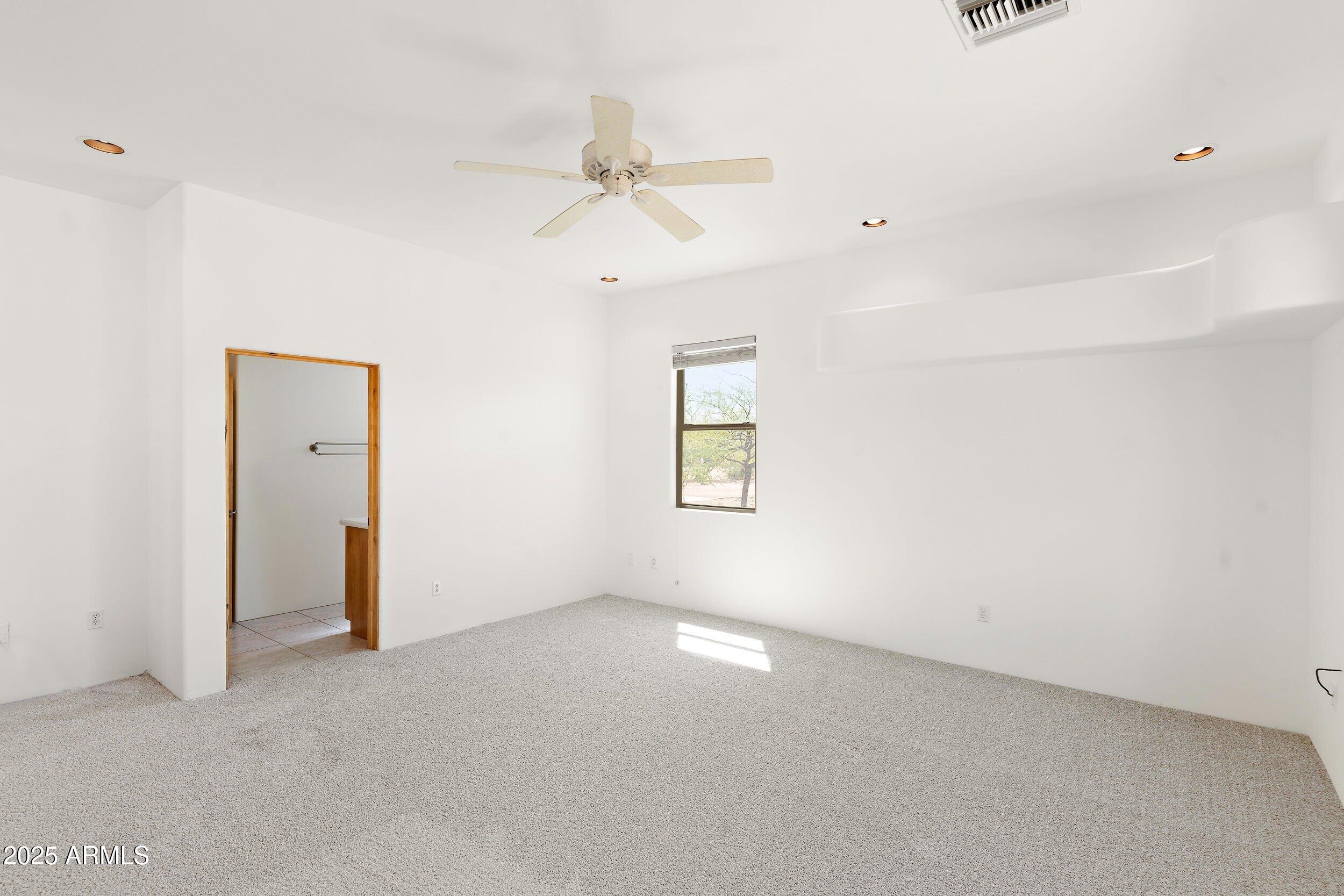 14036 East Ranch Road Scottsdale, AZ 85262 - Photo 15 of 32 an empty room with a window and a ceiling fan