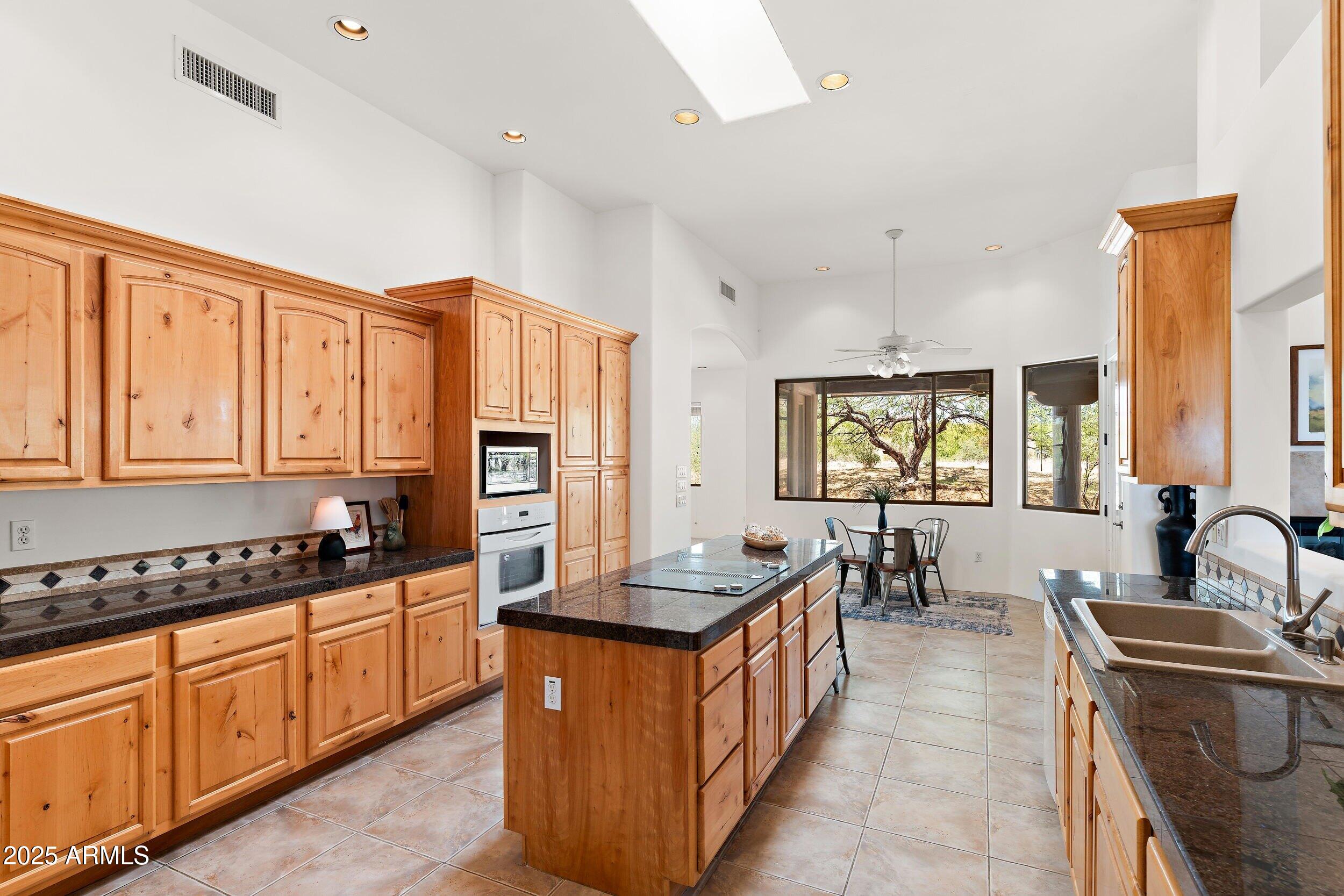 14036 East Ranch Road Scottsdale, AZ 85262 - Photo 5 of 32 a kitchen with stainless steel appliances granite countertop a stove a sink dishwasher and cabinets with wooden floor