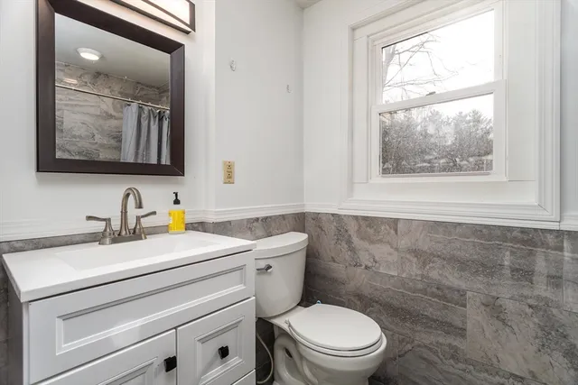 a bathroom with a toilet a sink and mirror