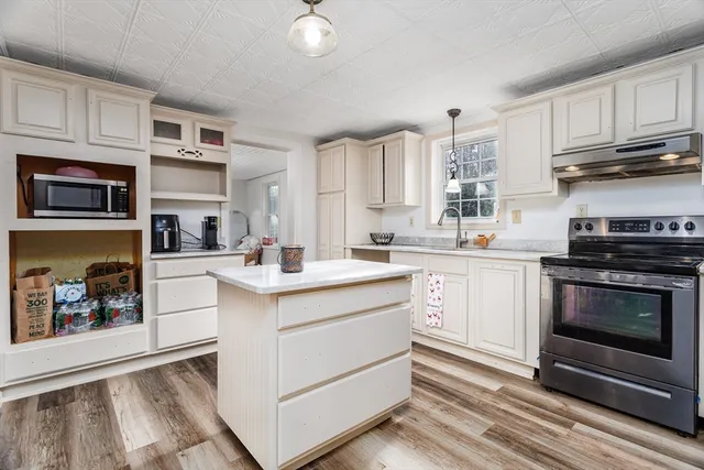 a kitchen with stainless steel appliances granite countertop a stove and white cabinets