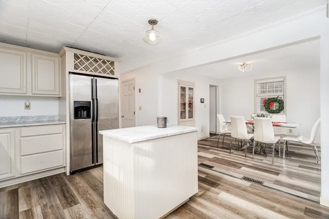 a living room with stainless steel appliances kitchen island granite countertop furniture and a refrigerator