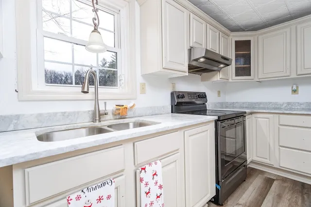 a kitchen with stainless steel appliances granite countertop a sink and a white cabinets